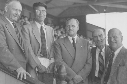 a group of men in business suits and ties posing for a picture