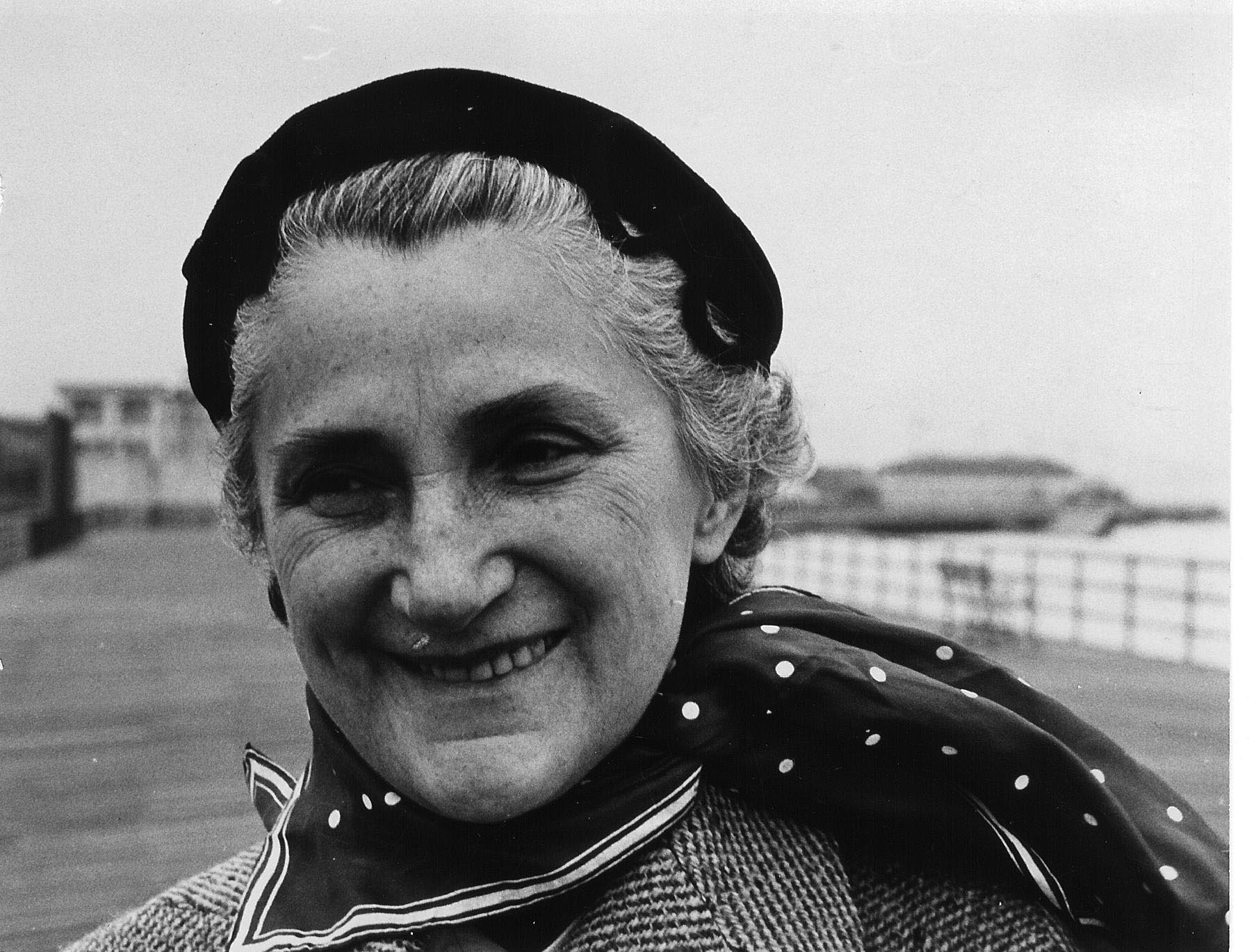 an older woman with a hat on smiling