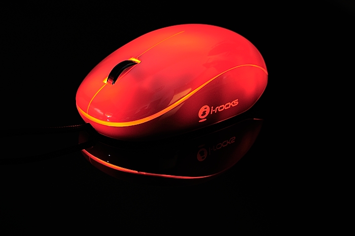 the red computer mouse is on a table