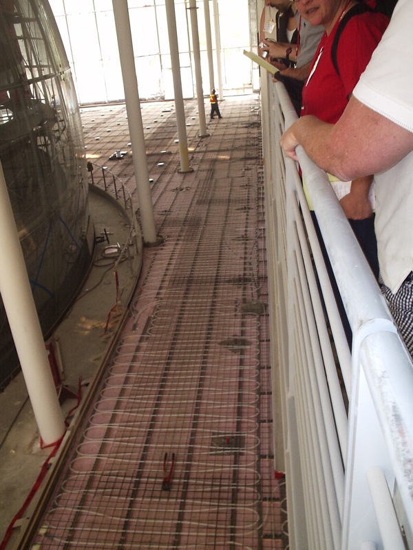 a group of people look at the construction work on a metal floor