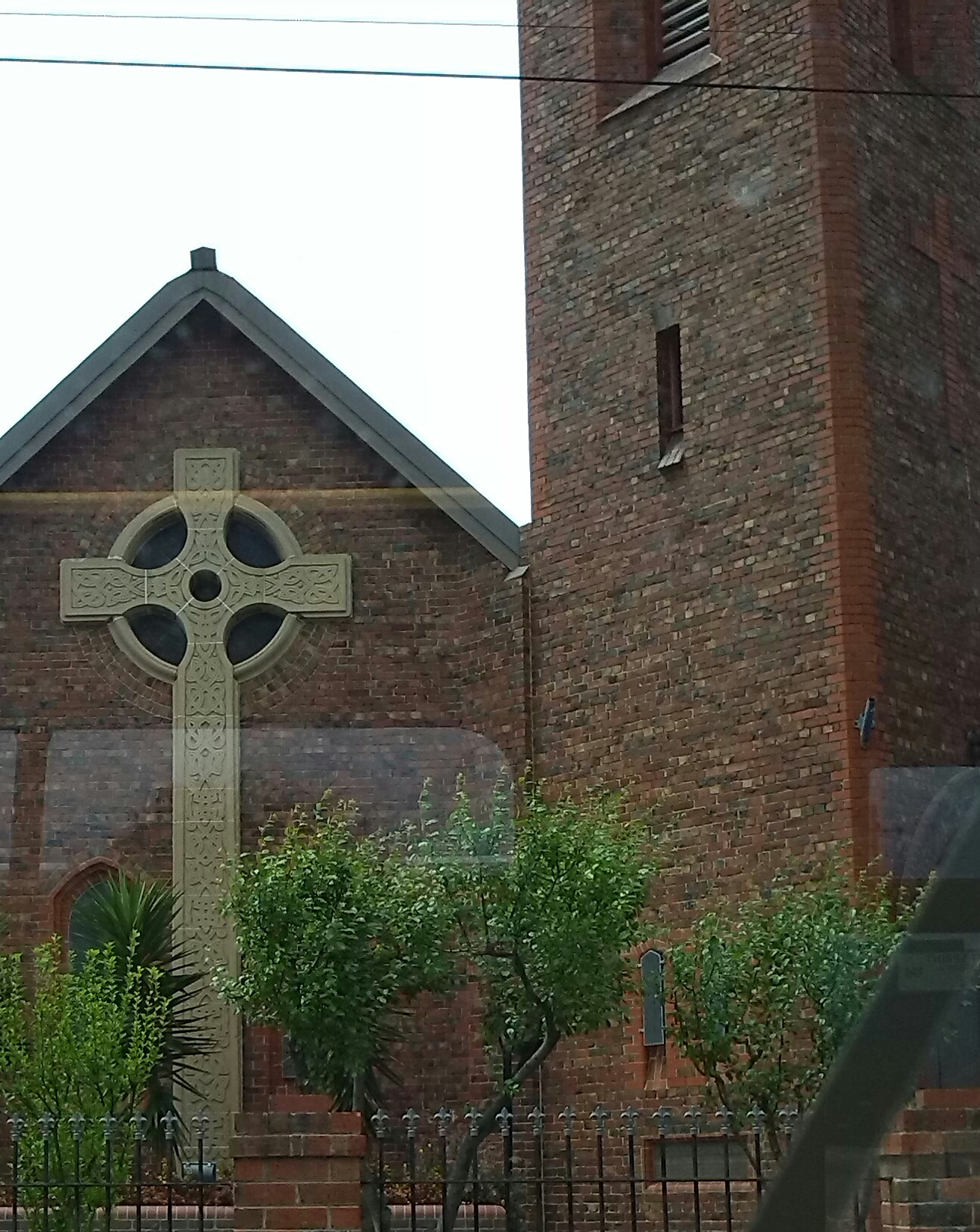 a large cross on a pole in front of a building