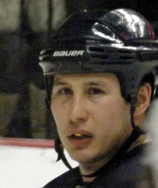 a male hockey player with a black uniform on