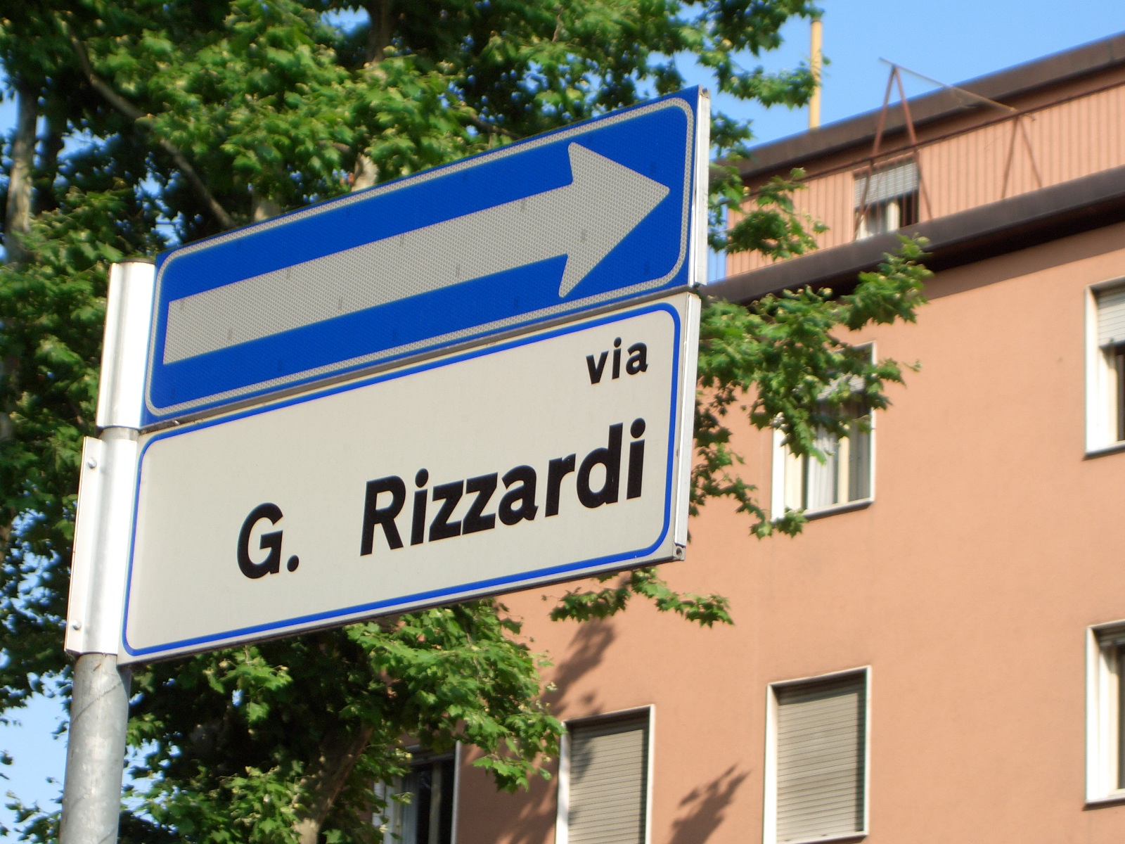 a blue and white street sign in front of a building