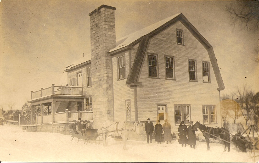 an old - fashioned house with men in front walking towards the house