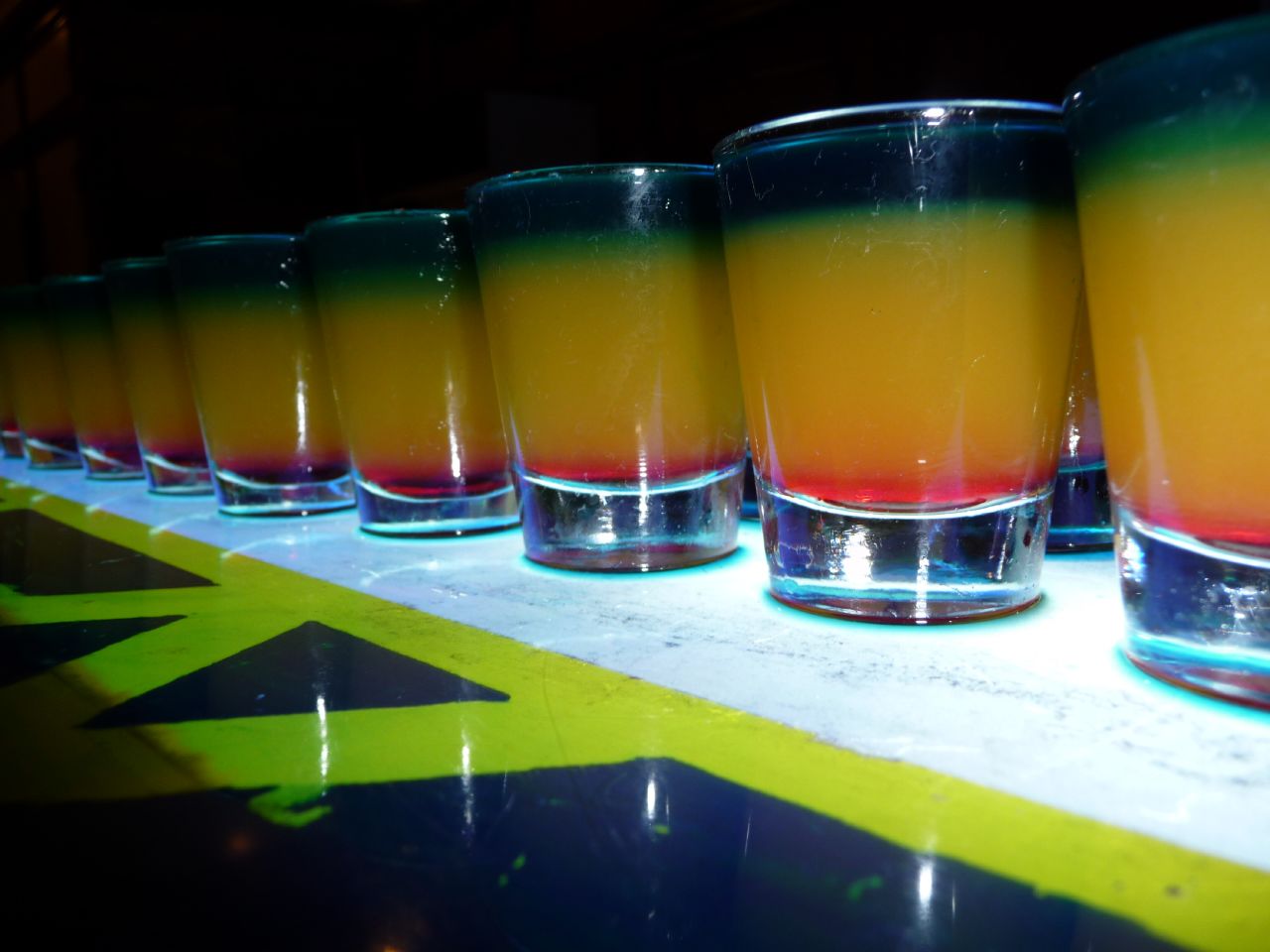 a row of glasses filled with colorful liquid