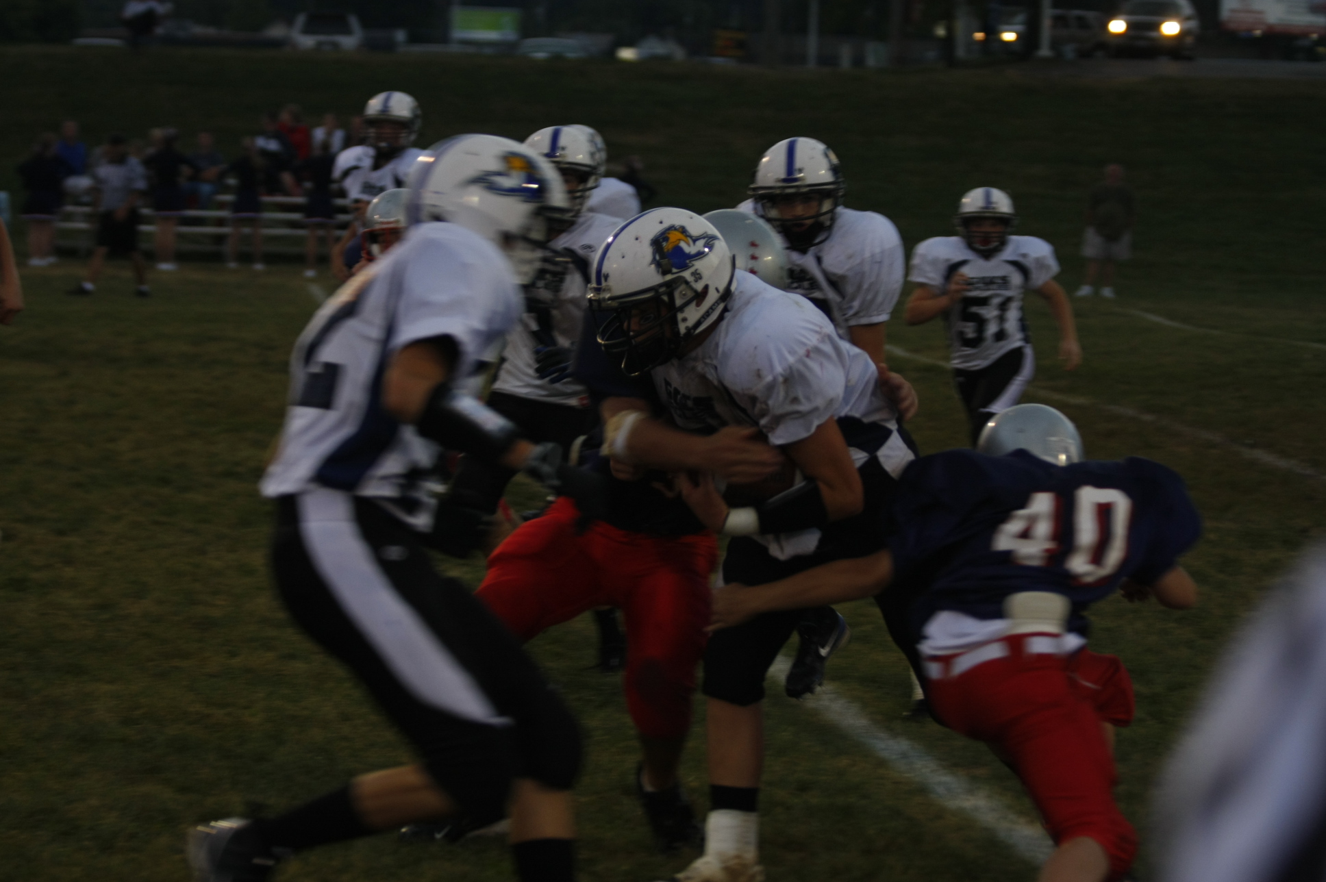 some football players with helmets are hugging