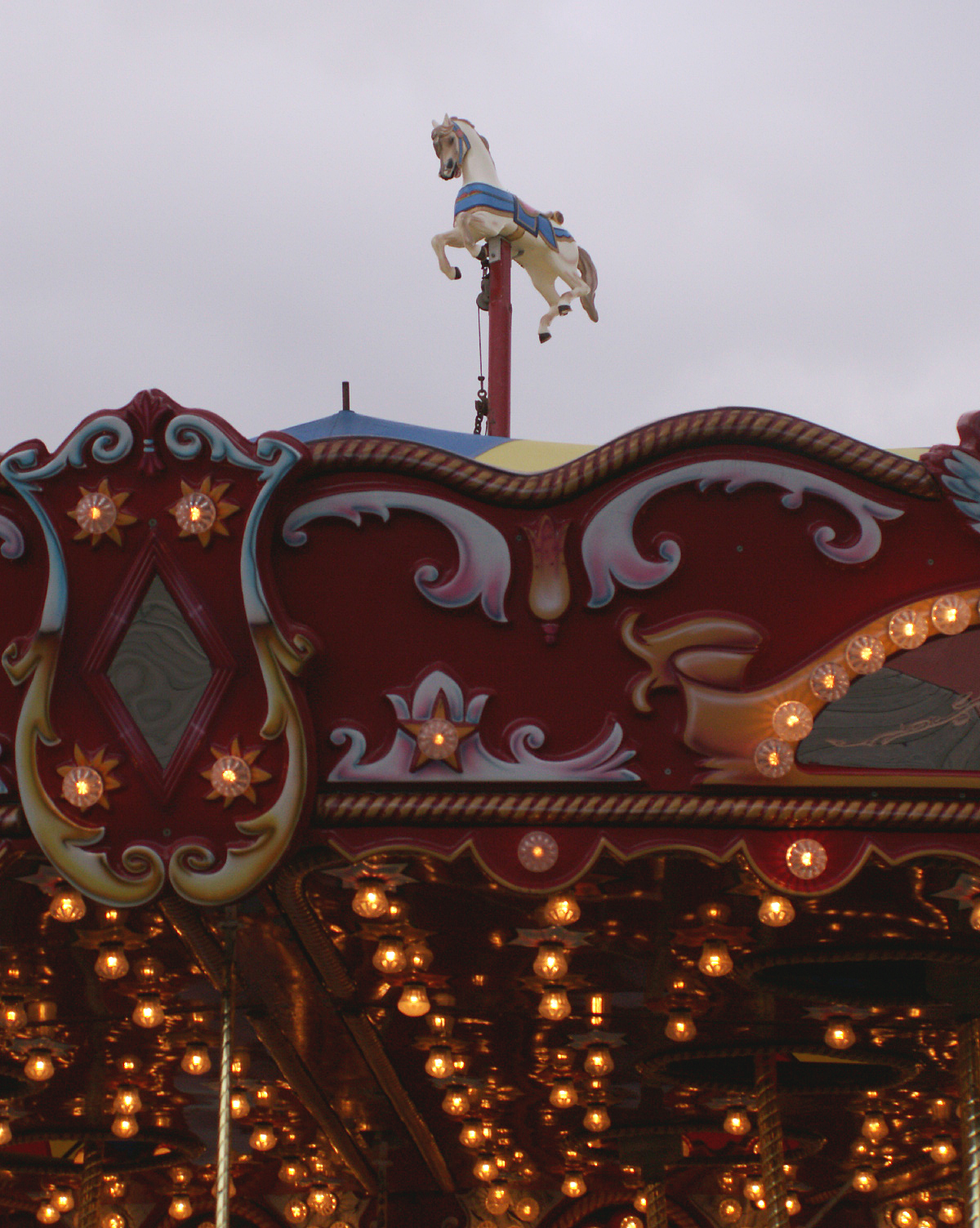 an ornately decorated ride on a fairground with lights in the background