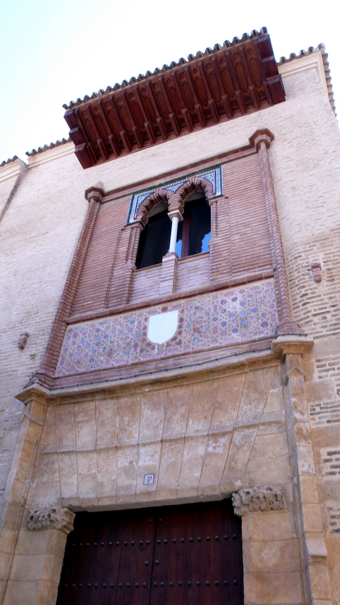 a tall building with two wooden doors and a window