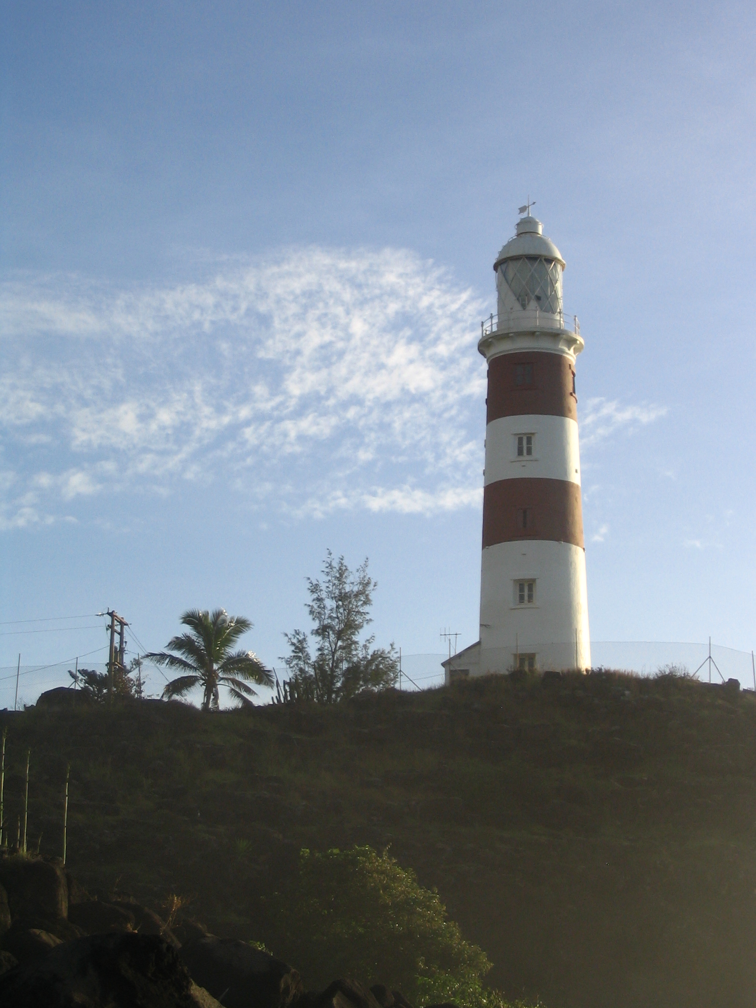 a white and red light house on top of a hill