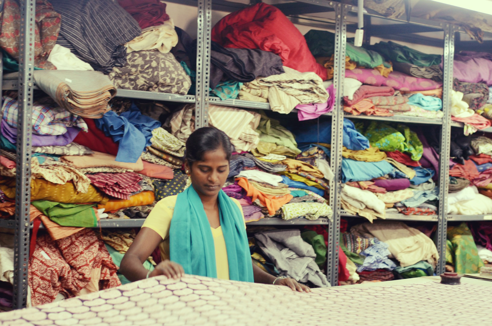 woman working in a clothing store with cloths for sale