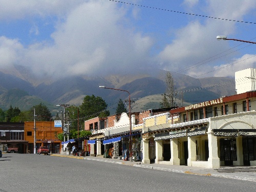 an empty street near some buildings and mountains