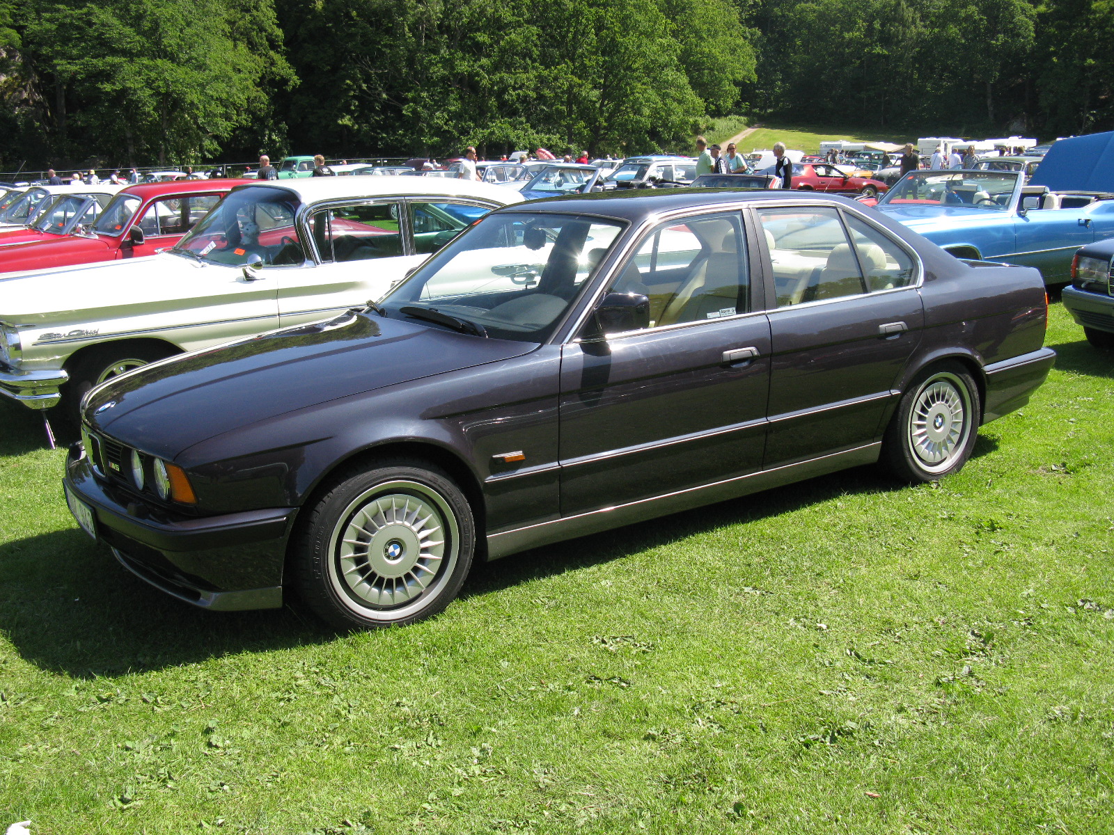 three car parked in a field with another car