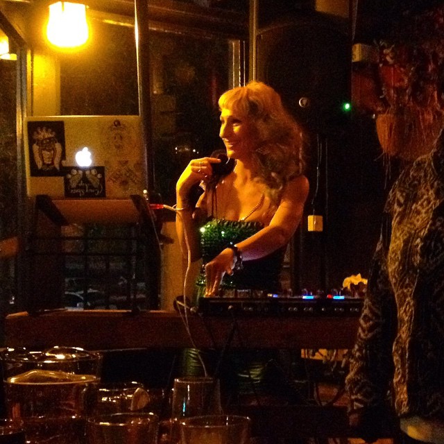 woman singing in front of two friends at a table