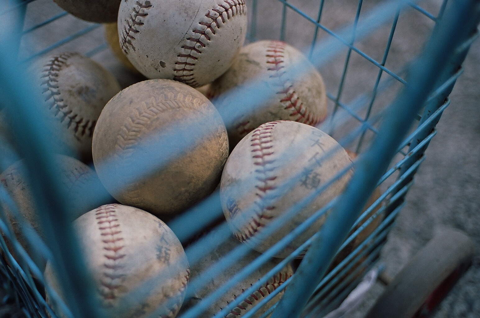 many baseballs stacked together in a cart