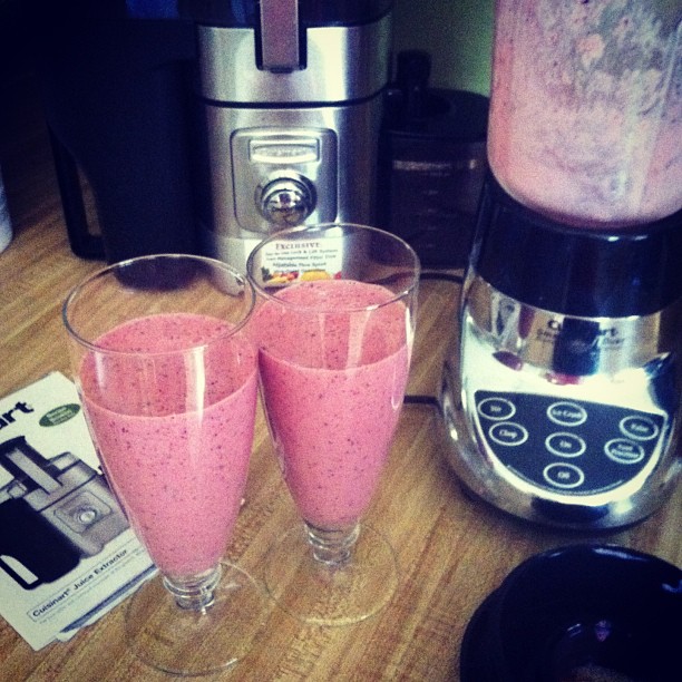 some smoothies with pink colored milk in a blender