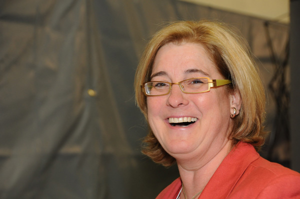 a woman with glasses on smiling at the camera