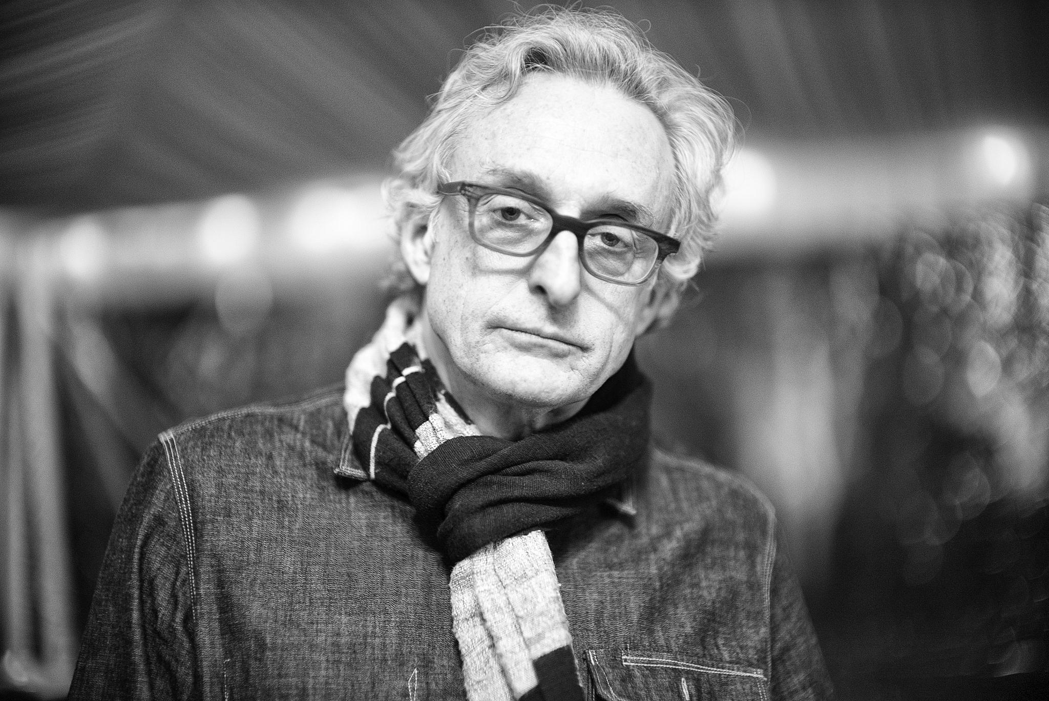 a black and white po of a man wearing glasses and a scarf