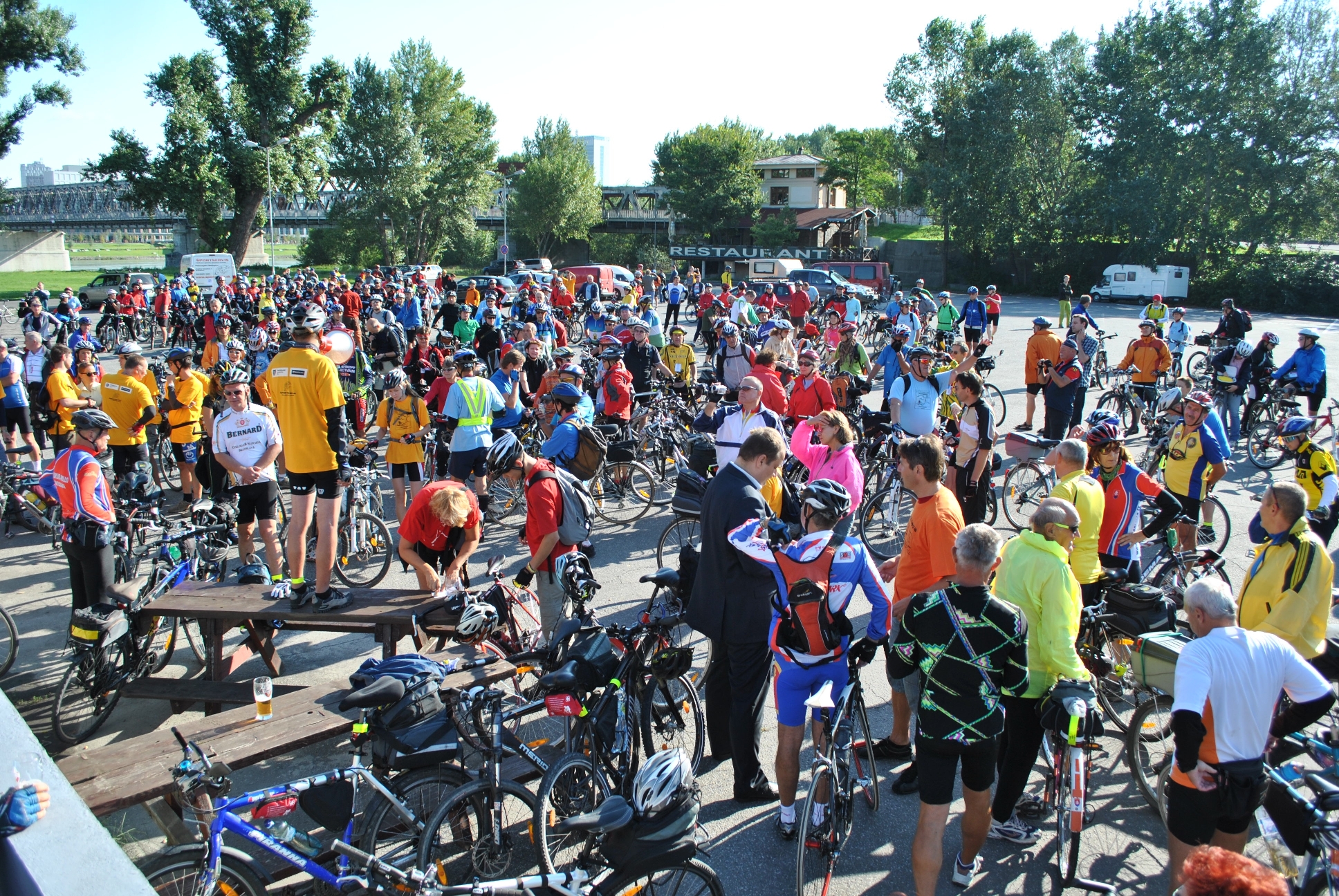 the large group of people are walking around with their bikes