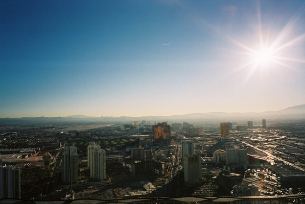 the sun shining over a city with high rise buildings