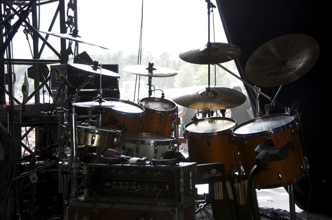 several drums on a stage with musical equipment in the background