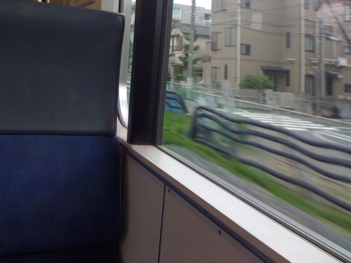 train view from inside of window, with building outside
