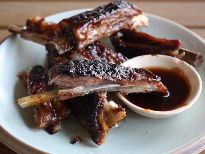 ribs, dipping sauce and bread on a plate