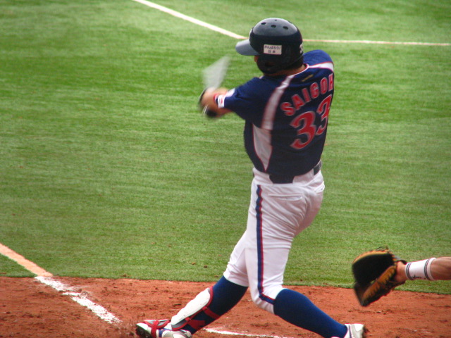 a baseball player in blue and white uniform is swinging at a ball
