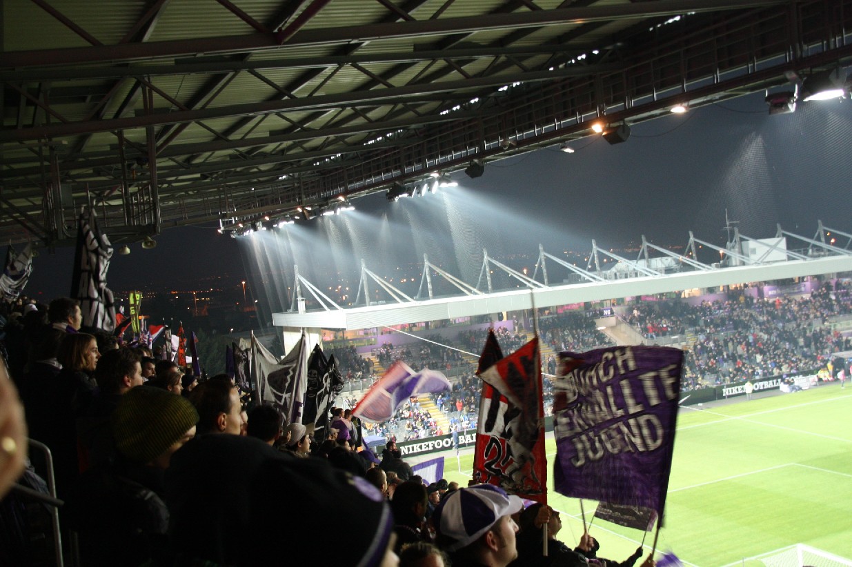 several people are watching a match at a stadium