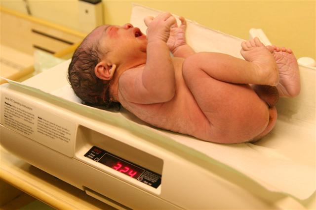 a baby lying on the scale of a birth machine