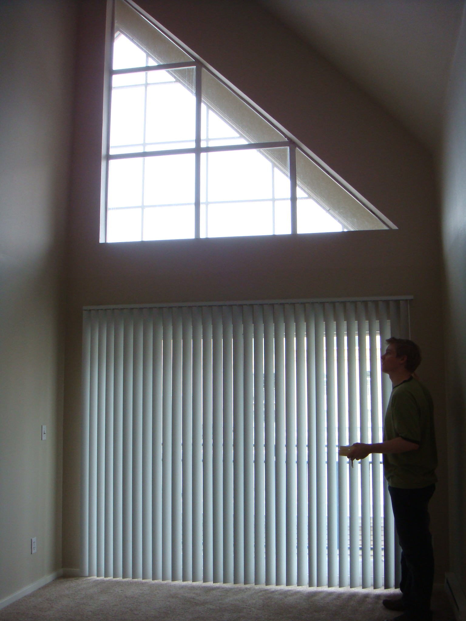 the inside of an empty house with a person standing in front of a window