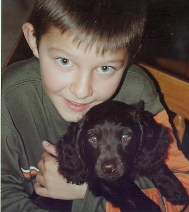 a boy holding a small dog in his arms