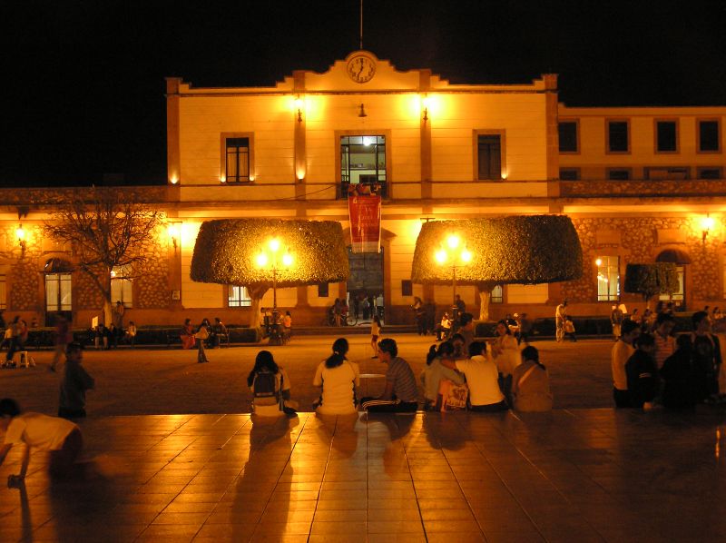 a group of people sitting outside a large building
