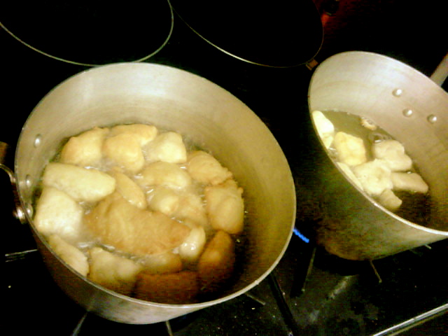 two pots with food inside of them on a stove top
