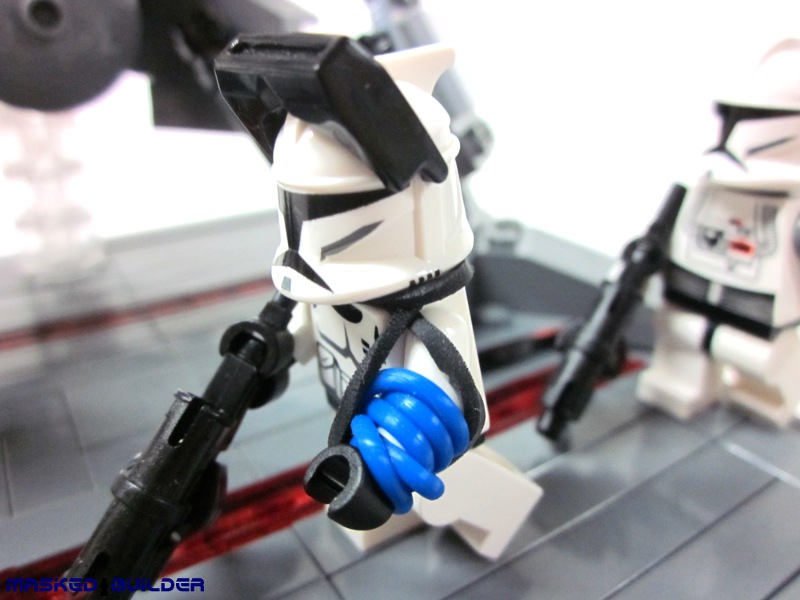 a lego storm trooper with his arms out standing next to a lego character