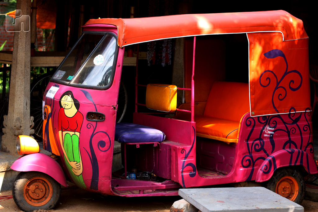 an colorful vehicle sits in front of a garage