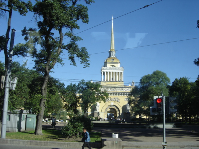 a large church with a tall steeple next to a red traffic light