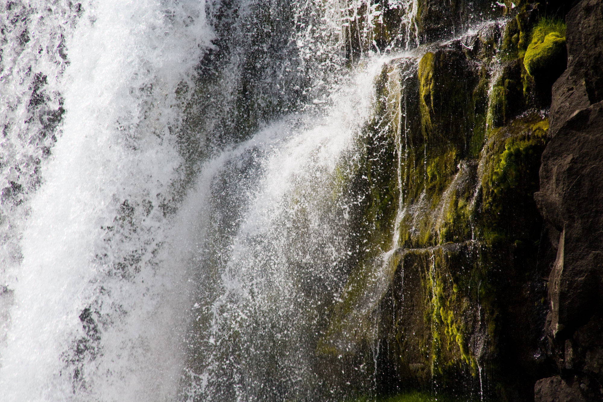 water being generated out from underneath a large waterfall