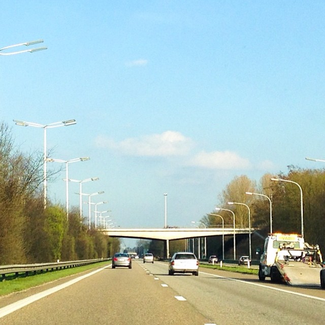 a truck is moving down the road in front of the cars