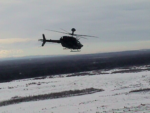 an aerial image of a helicopter flying above a snowy landscape
