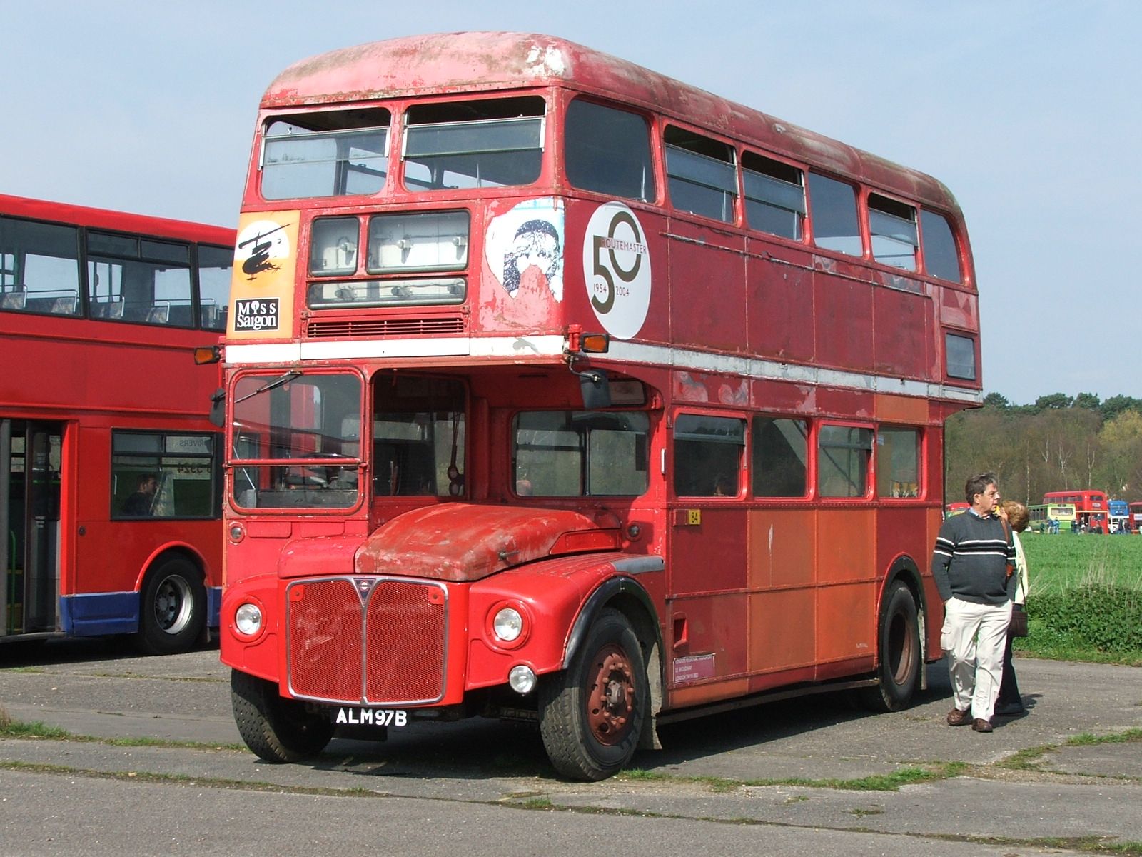 a double decker bus sits parked beside another bus