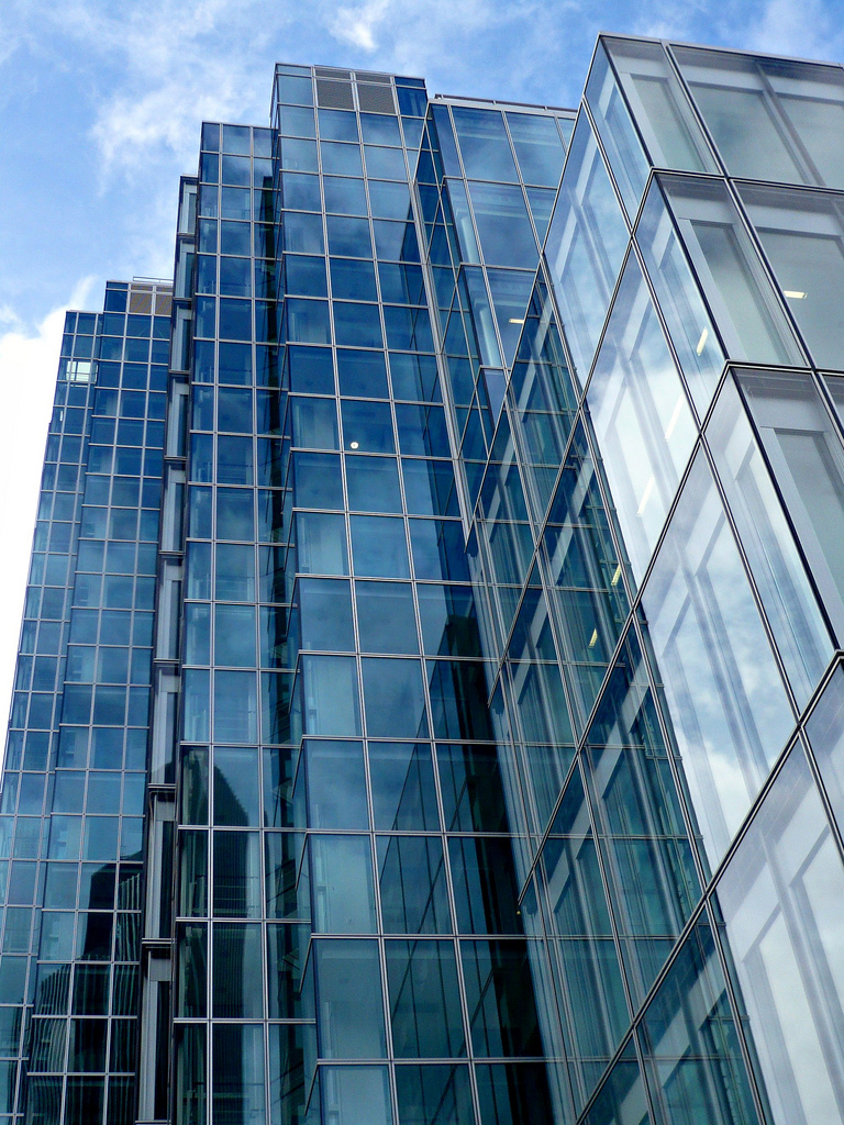 a blue sky is reflected in this glass building