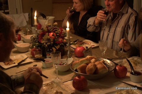 a table set with food and people sharing dinner