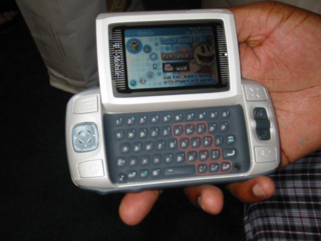 a hand holding an open smart phone that has a keyboard in it