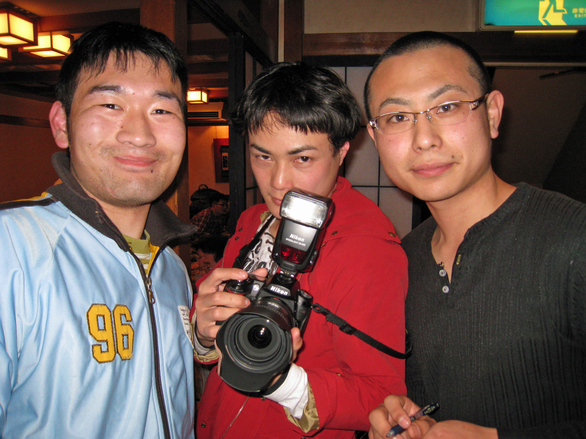 three young men posing with a camera on a trip