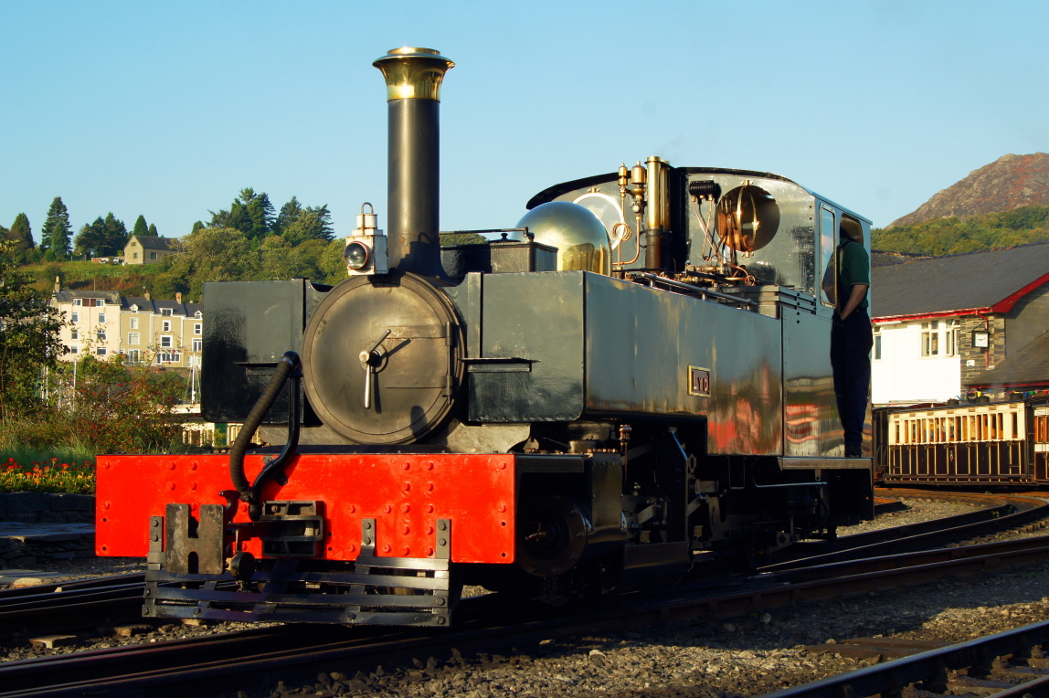 an old fashioned steam engine sitting on the tracks
