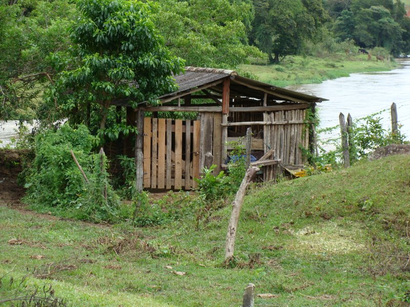 an outhouse along the side of the river