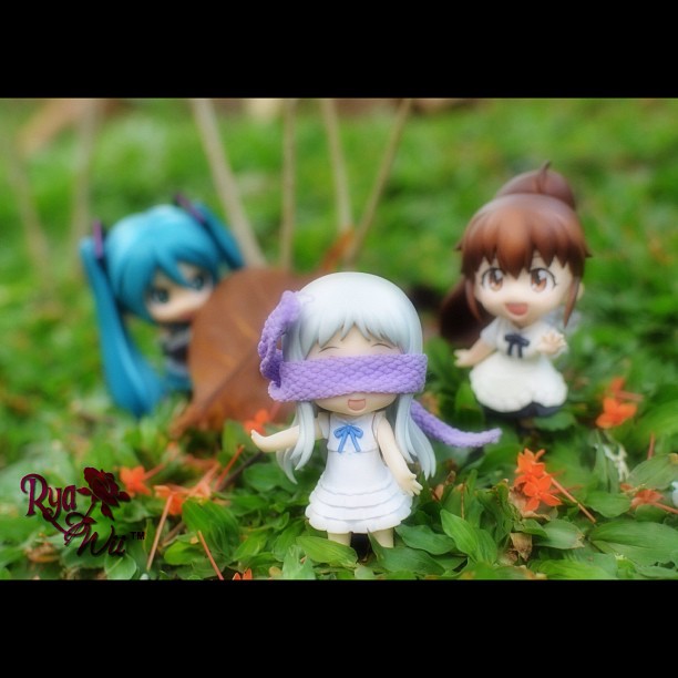 three miniature anime figures standing in a field