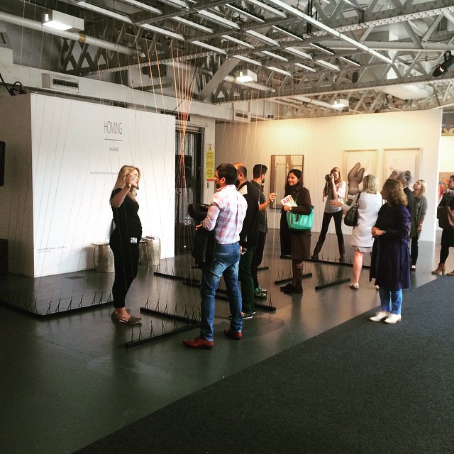 a group of people standing in a room talking and watching tv