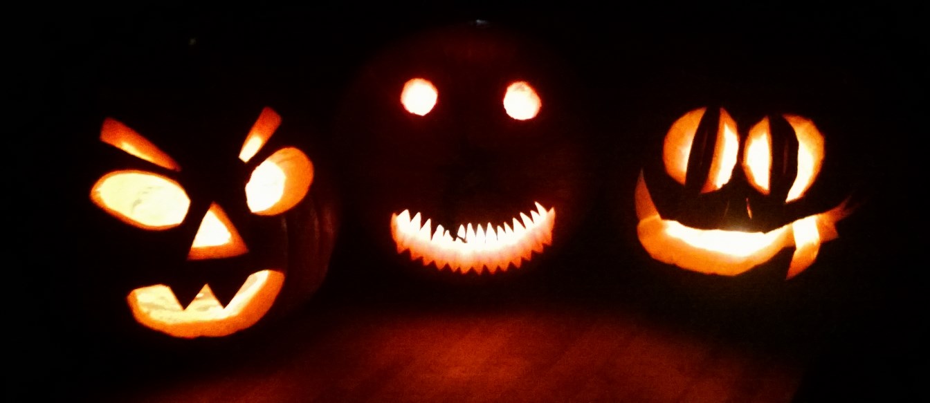 three carved pumpkins in various shapes and sizes