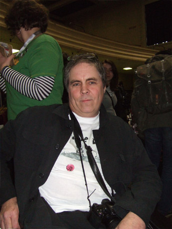 an older man sitting in a chair in front of a table